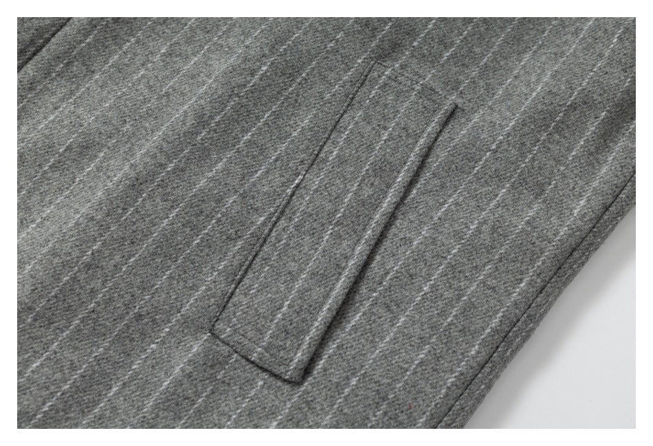 Close-up of a slanted welt pocket on the jacket's gray pinstriped panel.