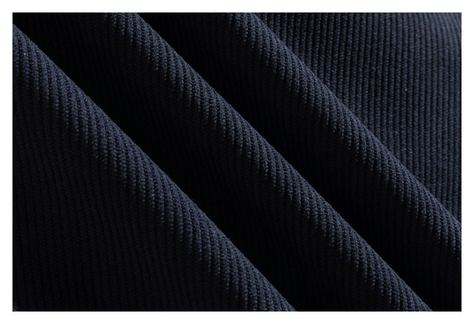 Macro view of dark navy ribbed fabric arranged in diagonal folds.