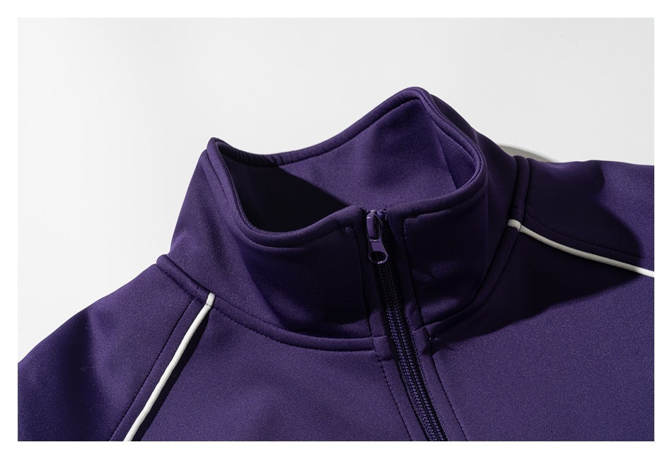 Close-up of a purple jacket's stand collar, front zipper and white shoulder piping.