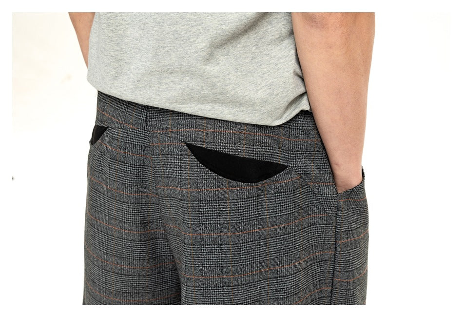 Close-up of the shorts' gray plaid waistband and rear pocket, with thin rust-colored lines.