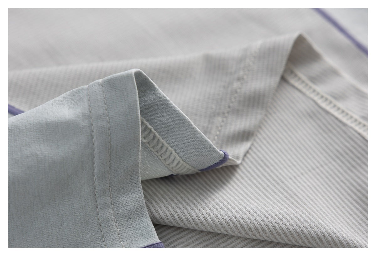 Close-up of the ivory garment's sleeve cuff, seam stitching, and lavender edging.