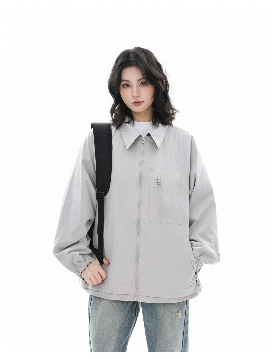 Model wearing a light gray zip-front jacket with a pointed collar, elastic cuffs, and a zippered chest pocket.