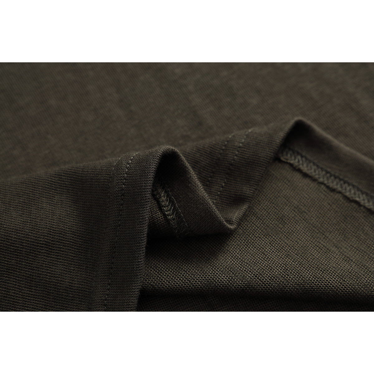 Close-up of the dark olive shirt's folded edge and overlocked seam stitching.