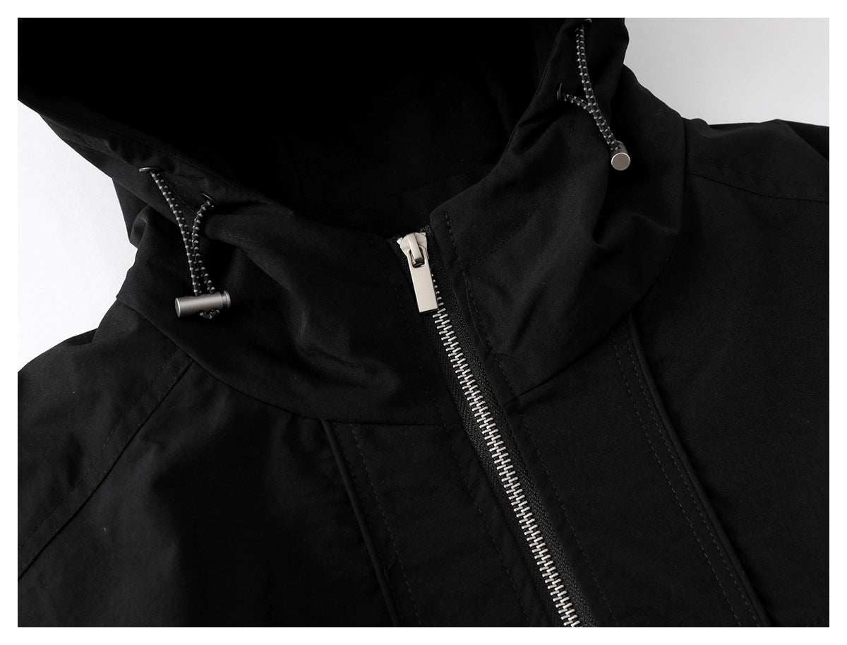 Close-up of a black jacket hood with drawcords and a silver front zipper.