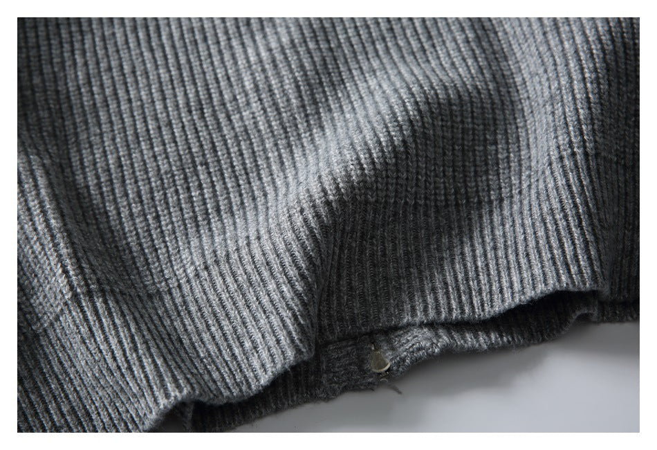 Close-up of the rib-knit edge and stitching on a gray sweater.