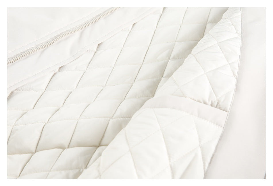 Close-up of white quilted garment lining with stitched panels and a zipper.
