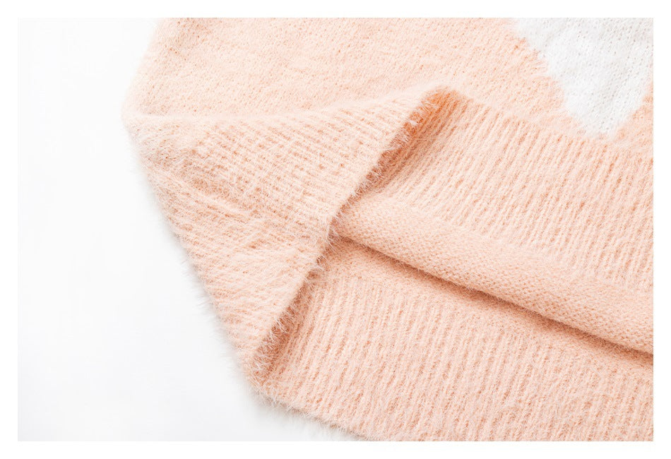 Close-up of a pale peach fuzzy knit garment with a folded ribbed edge.