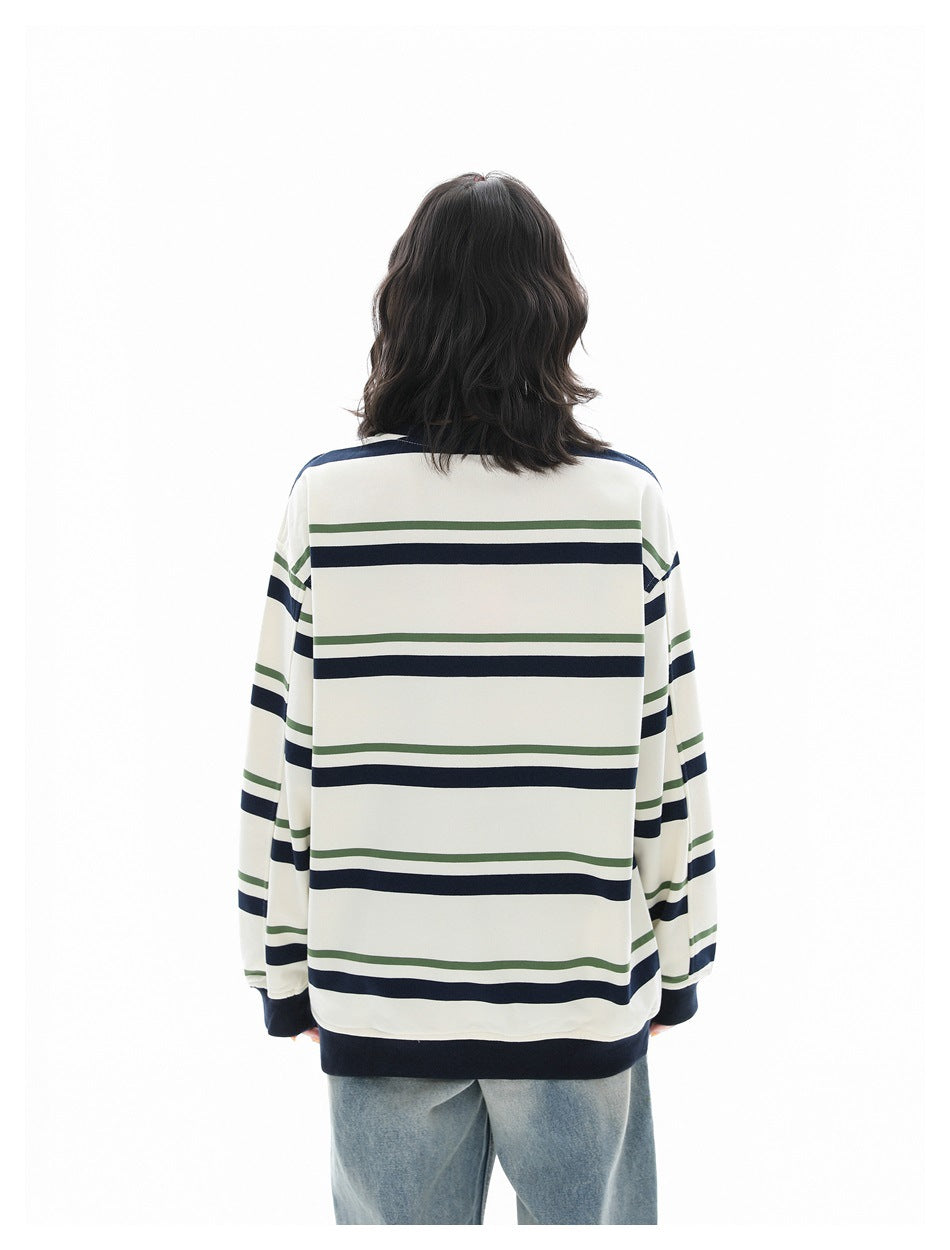 Back view of a person wearing an ivory long-sleeve shirt with navy and olive horizontal stripes and dark ribbed cuffs and