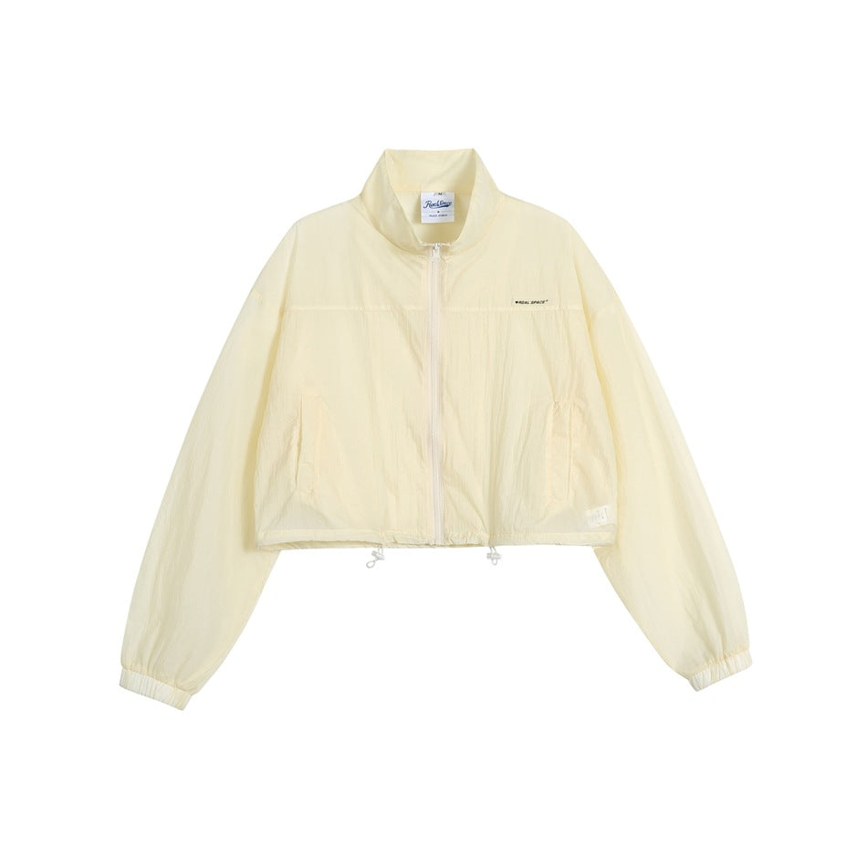 Pale yellow cropped zip-up jacket with stand collar, drawstring hem and elastic cuffs, flat front view