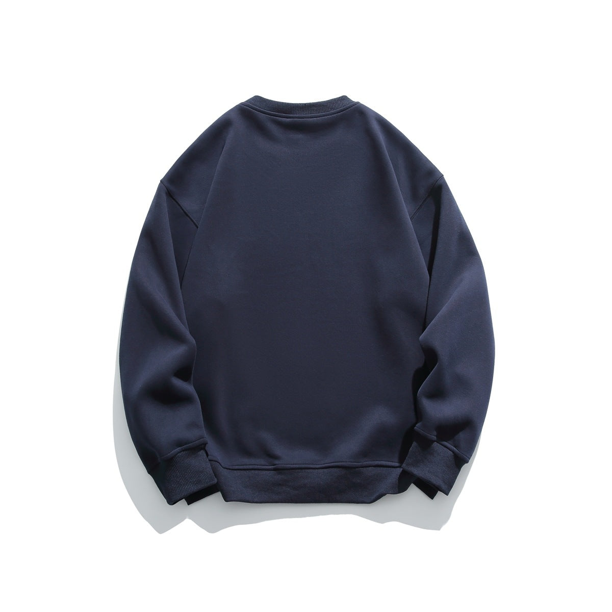 Back view of a plain navy crewneck sweatshirt with long sleeves and ribbed cuffs and hem.