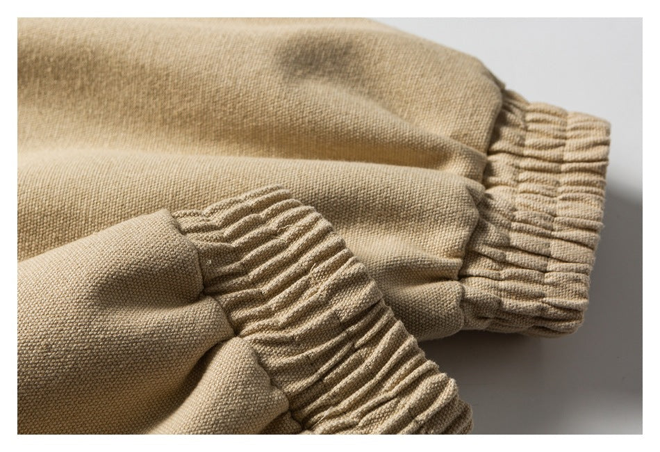 Close-up of gathered elastic cuffs on beige garment sleeves.