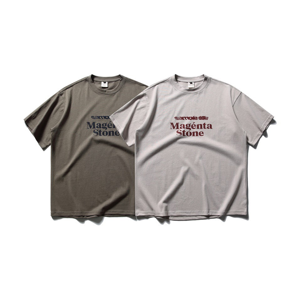 Two short-sleeve crew-neck T-shirts shown from the front in dark taupe and pale gray, each with chest lettering.