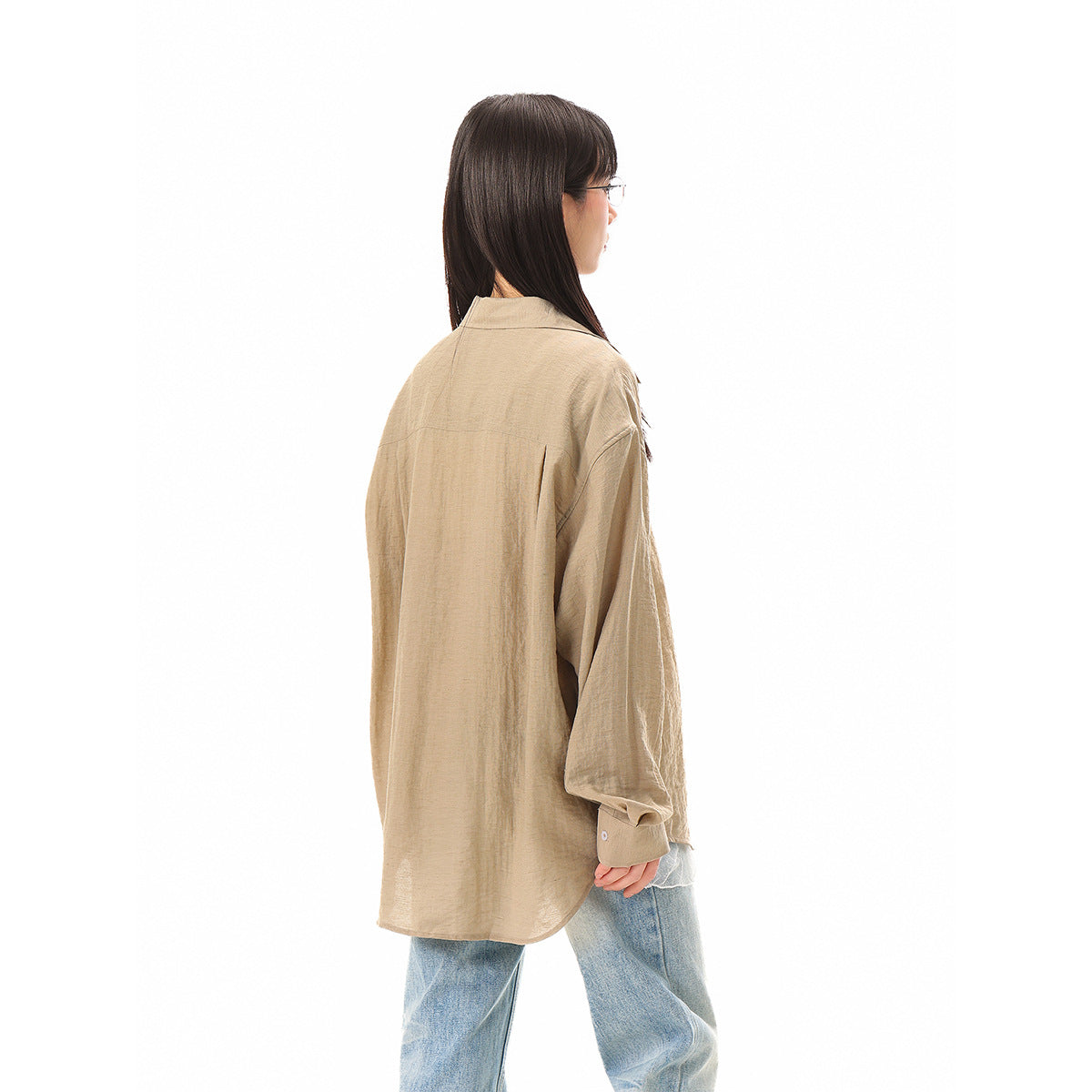 Back and side view of a model wearing an oversized taupe button-up shirt with light blue jeans.