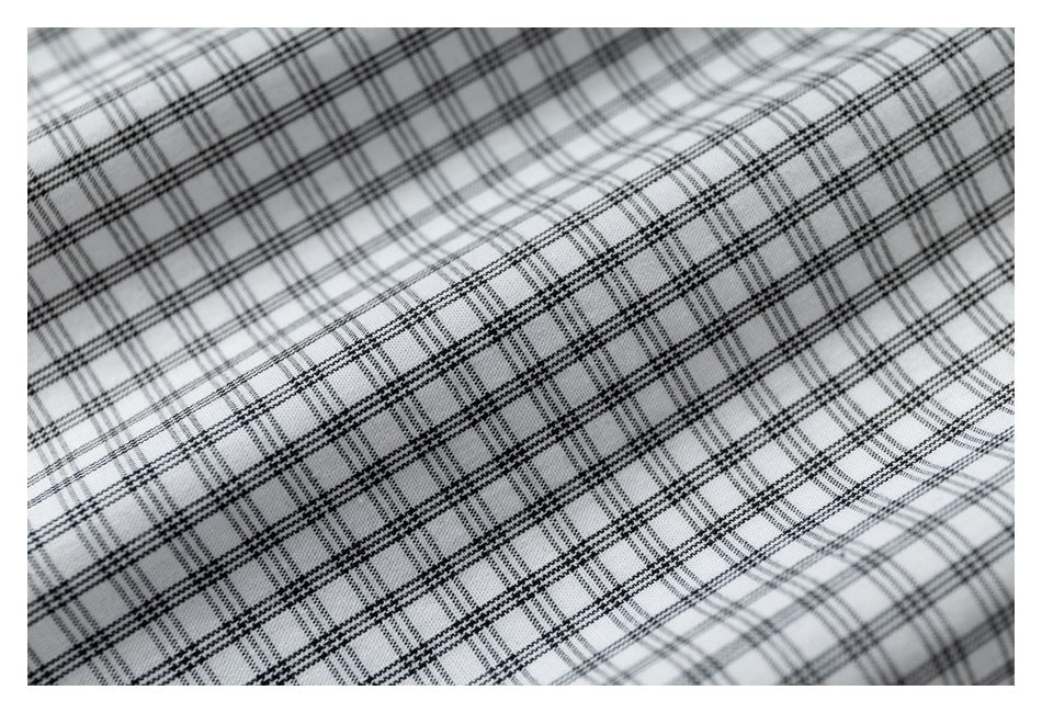 Macro view of the black-and-gray check pattern on the shirt fabric.