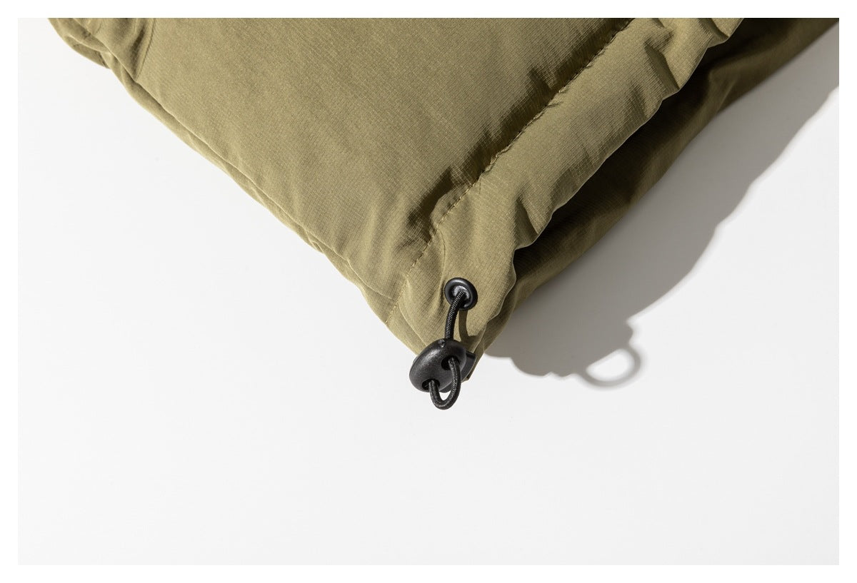 Close-up of the olive-tan jacket hem with a black elastic drawcord and toggle.