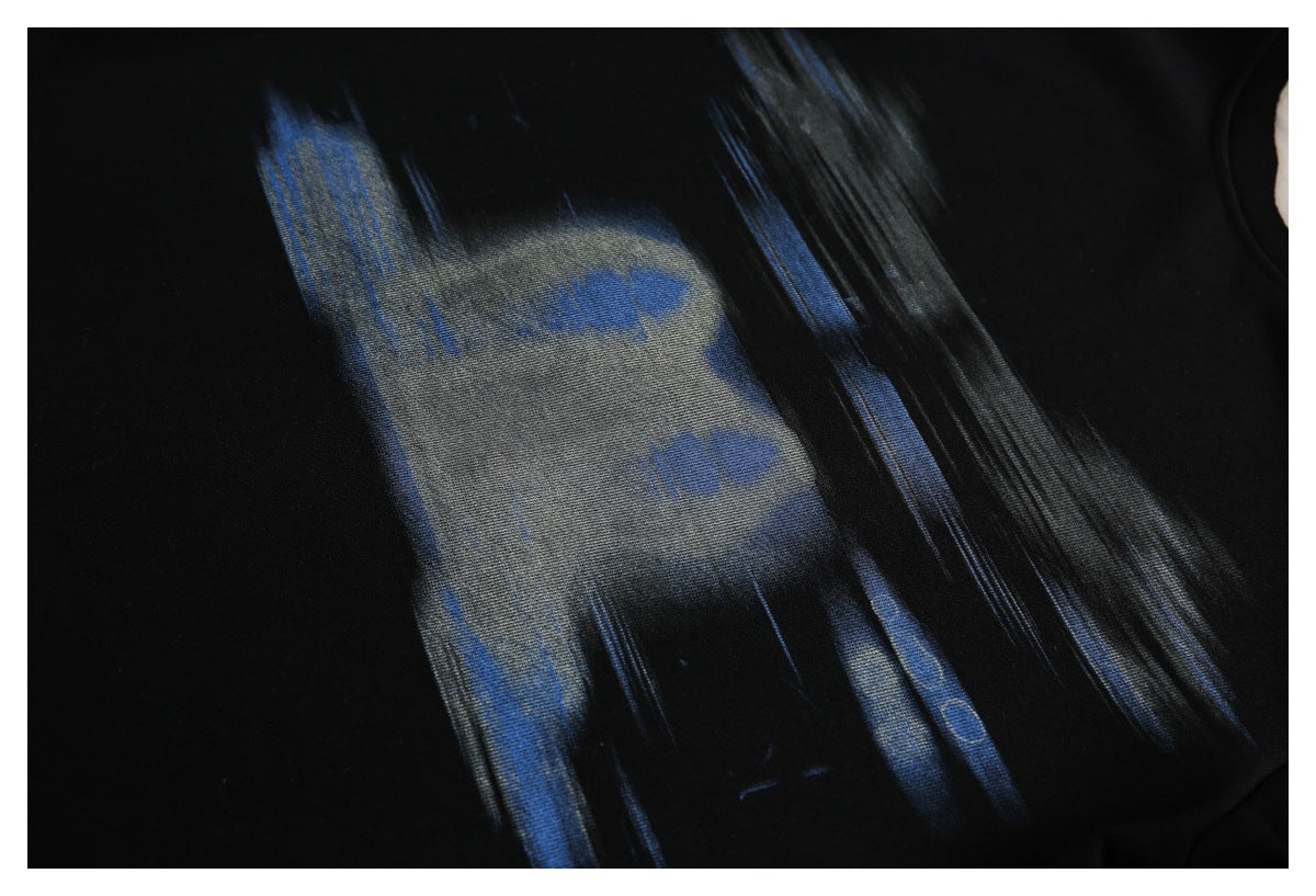 Close-up of a black garment with an abstract blue and gray printed design.