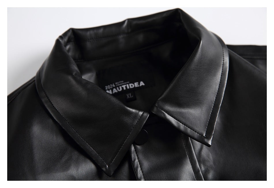 Close-up of a black jacket's pointed collar, covered button placket, and inner neck label.