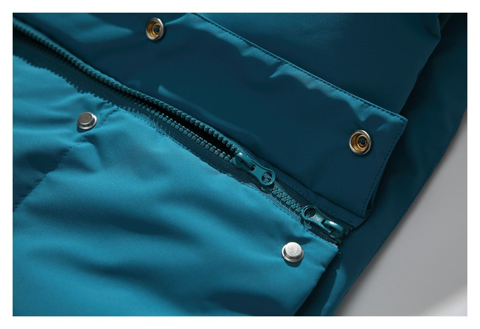 Close-up of the teal jacket's two-way zipper and metal snap fasteners.