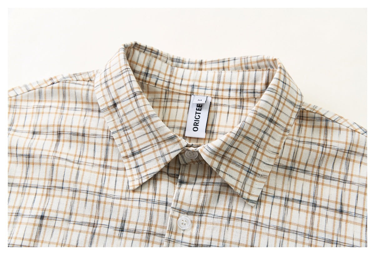 Close-up of the cream plaid button-up shirt collar, label, and upper chest.