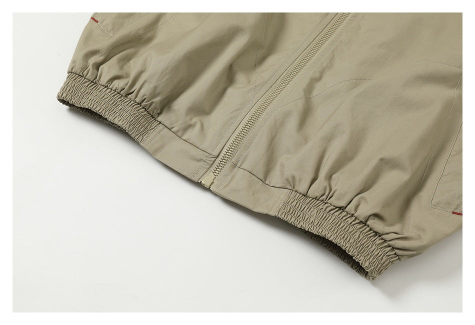 Close-up of a beige garment hem with a zipper and gathered elastic sections.