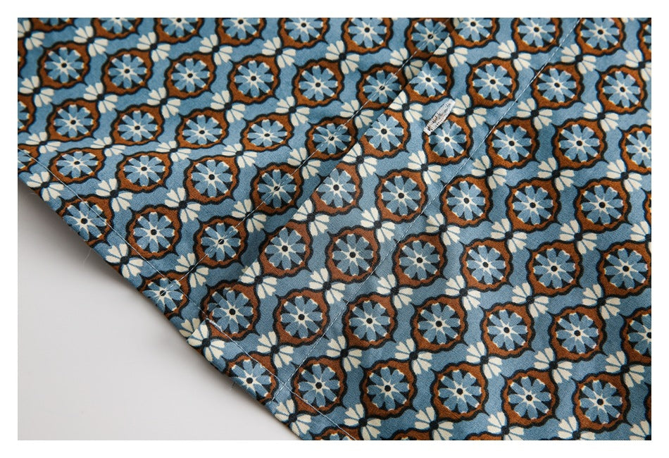 Close-up of the blue floral shirt hem with visible stitching and a small fabric label.