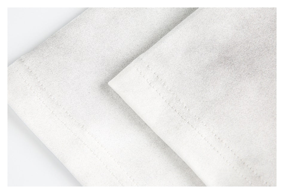 Close-up of off-white garment hems with parallel rows of stitching.