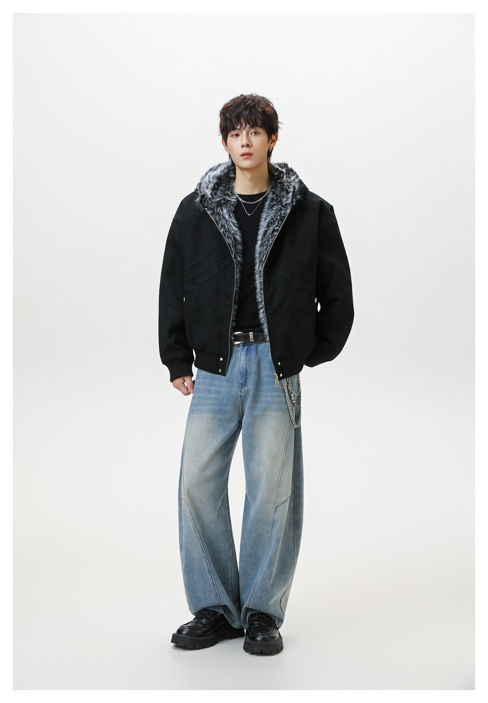 Full-length model wearing a black jacket with gray faux-fur hood trim, paired with loose light blue jeans.