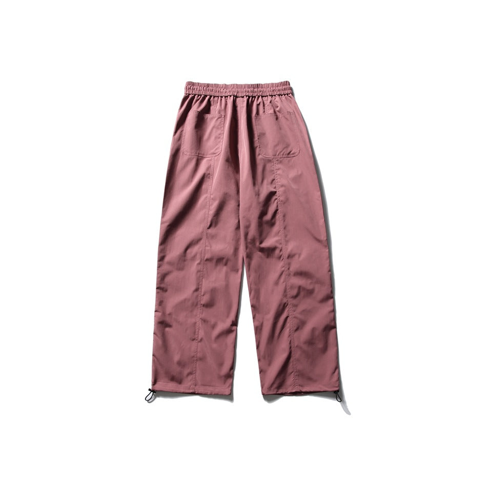 Back view of dusty rose wide-leg pants with an elastic waist, two patch pockets, and adjustable ankle cords.