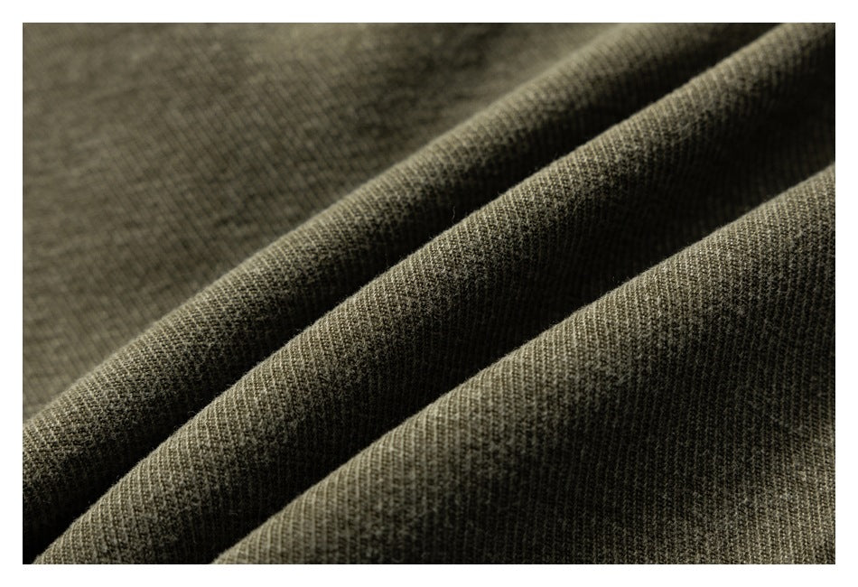 Macro view of olive-brown fabric gathered into folds, showing its textured weave.