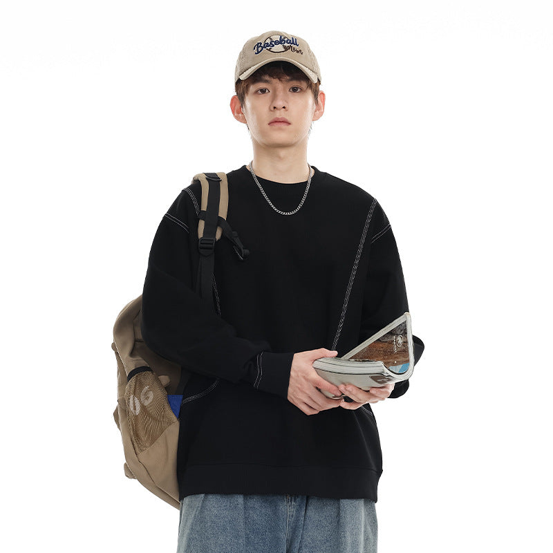 Model wearing a black contrast-stitched crewneck sweatshirt, with a backpack strap and pouch partly covering the front.