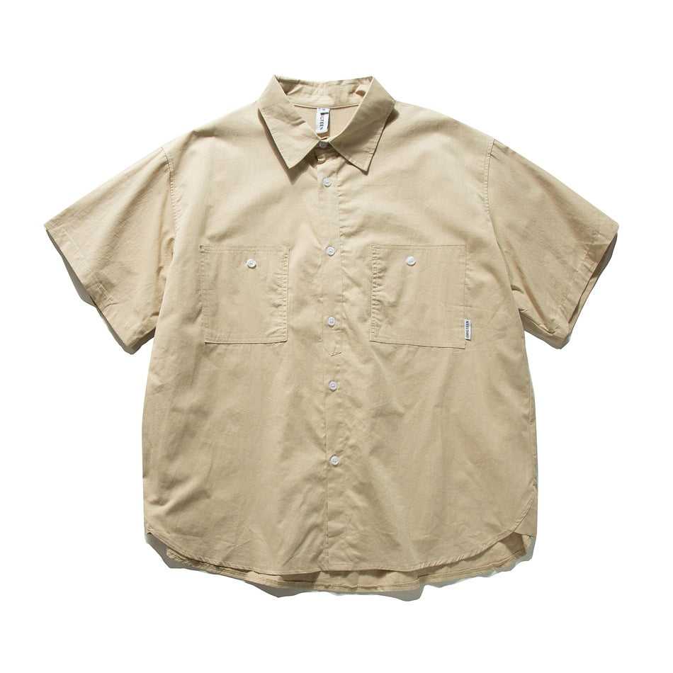 Khaki short-sleeve button-front shirt with two chest patch pockets and a curved hem, laid flat