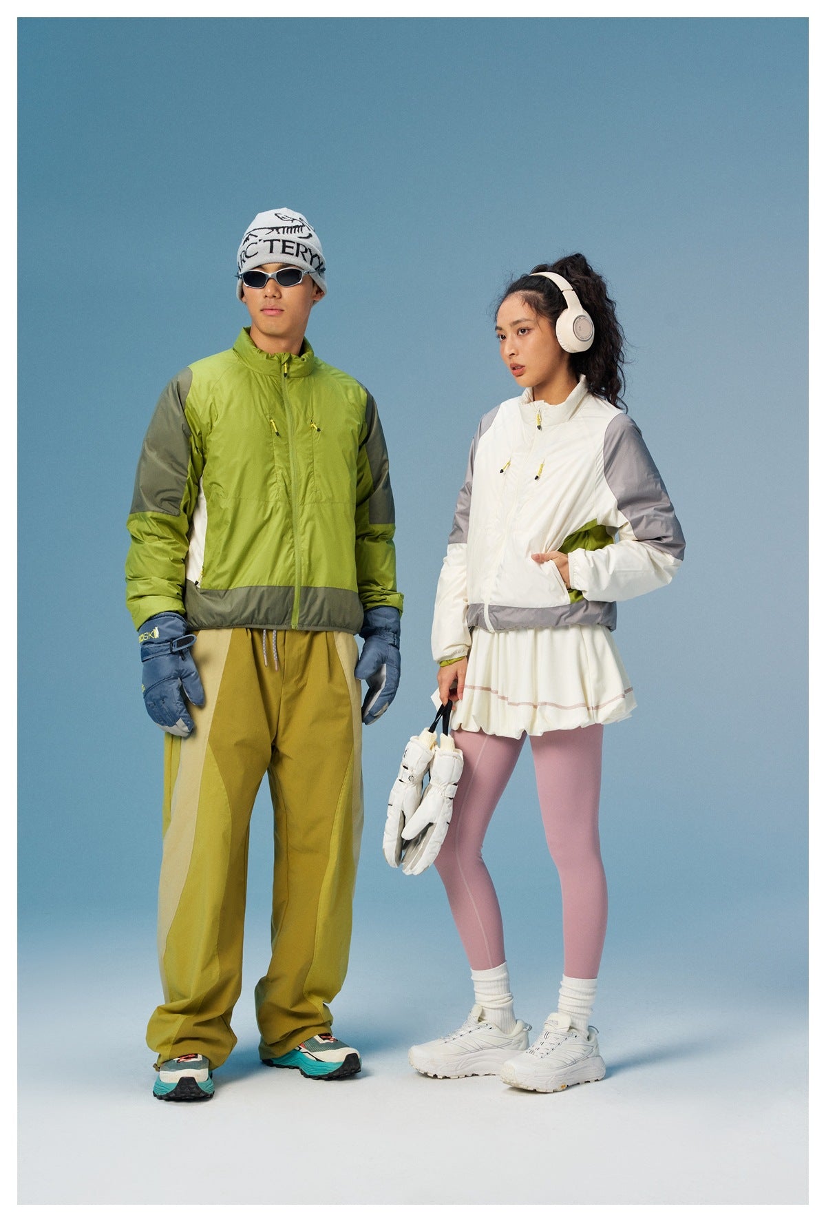 Two models wear colorways of a zip jacket: lime green with gray panels and white with gray sleeves and hem.