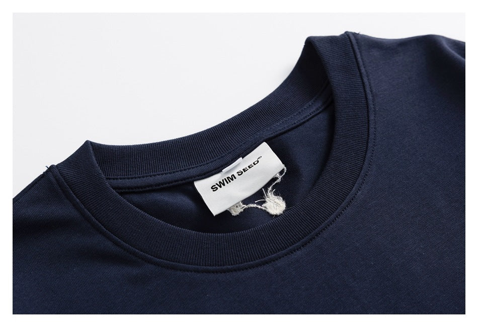 Close-up of a navy T-shirt crew neck and sewn-in white SWIM SEED label.