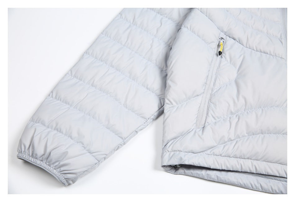 Close-up of a light gray quilted jacket sleeve with an elastic cuff and a zippered pocket.