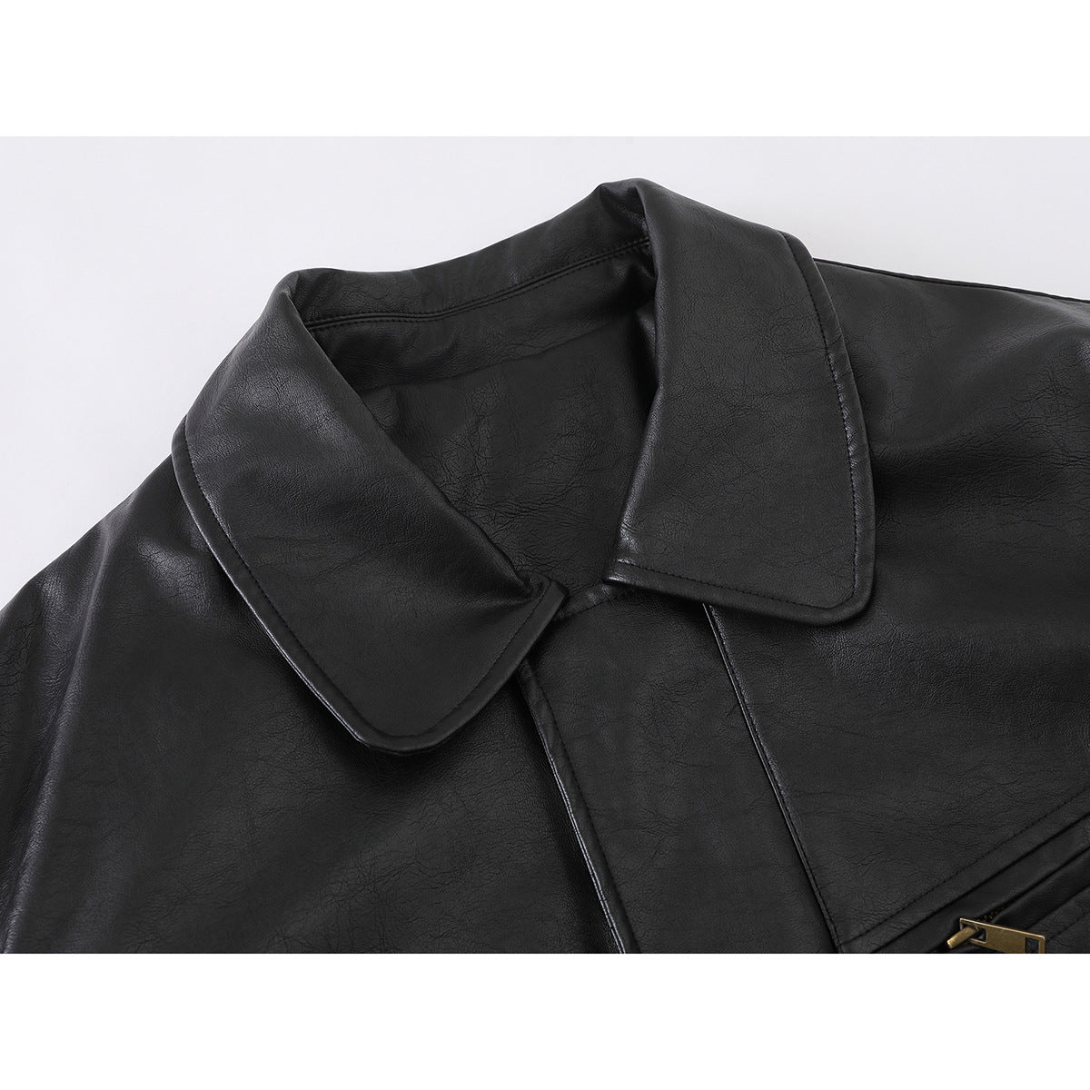 Close-up of a black jacket's wide collar and upper front, with a glimpse of brass-tone zipper hardware.