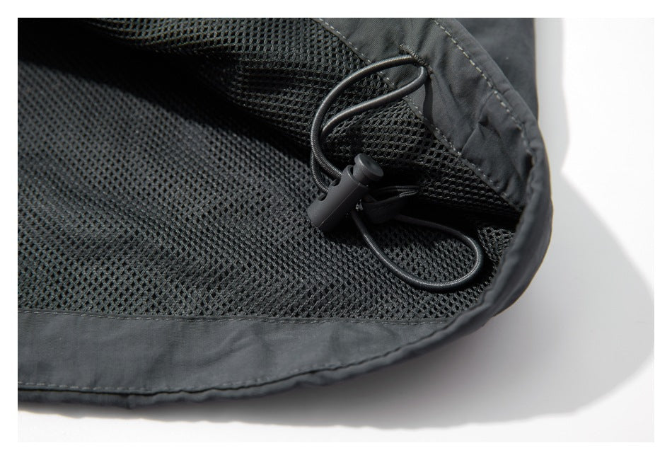 Close-up of black mesh lining and an adjustable elastic drawcord with a toggle inside the jacket.