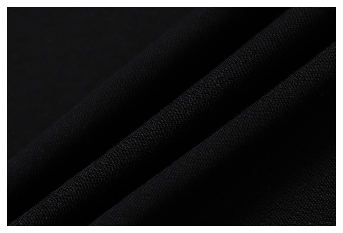 Macro view of black T-shirt fabric draped into soft folds.