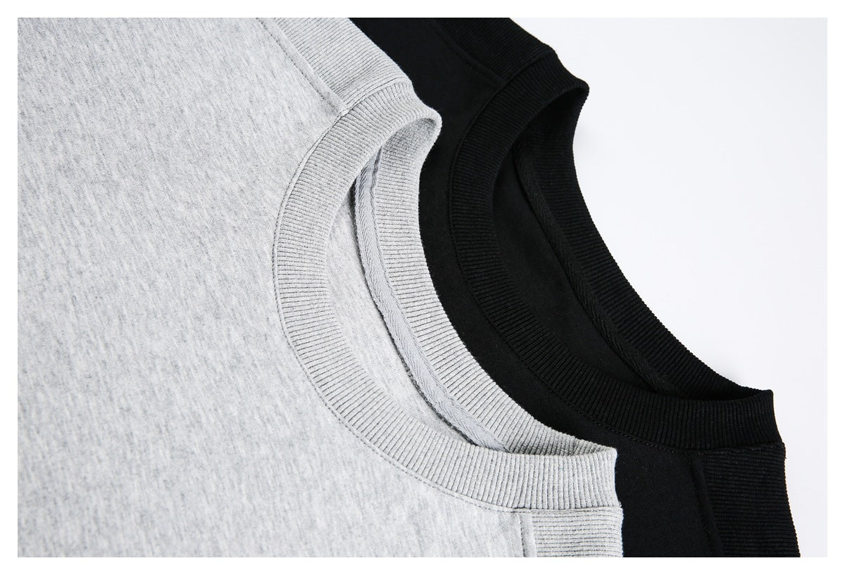 Close-up of ribbed crew necklines on light gray and black shirts.