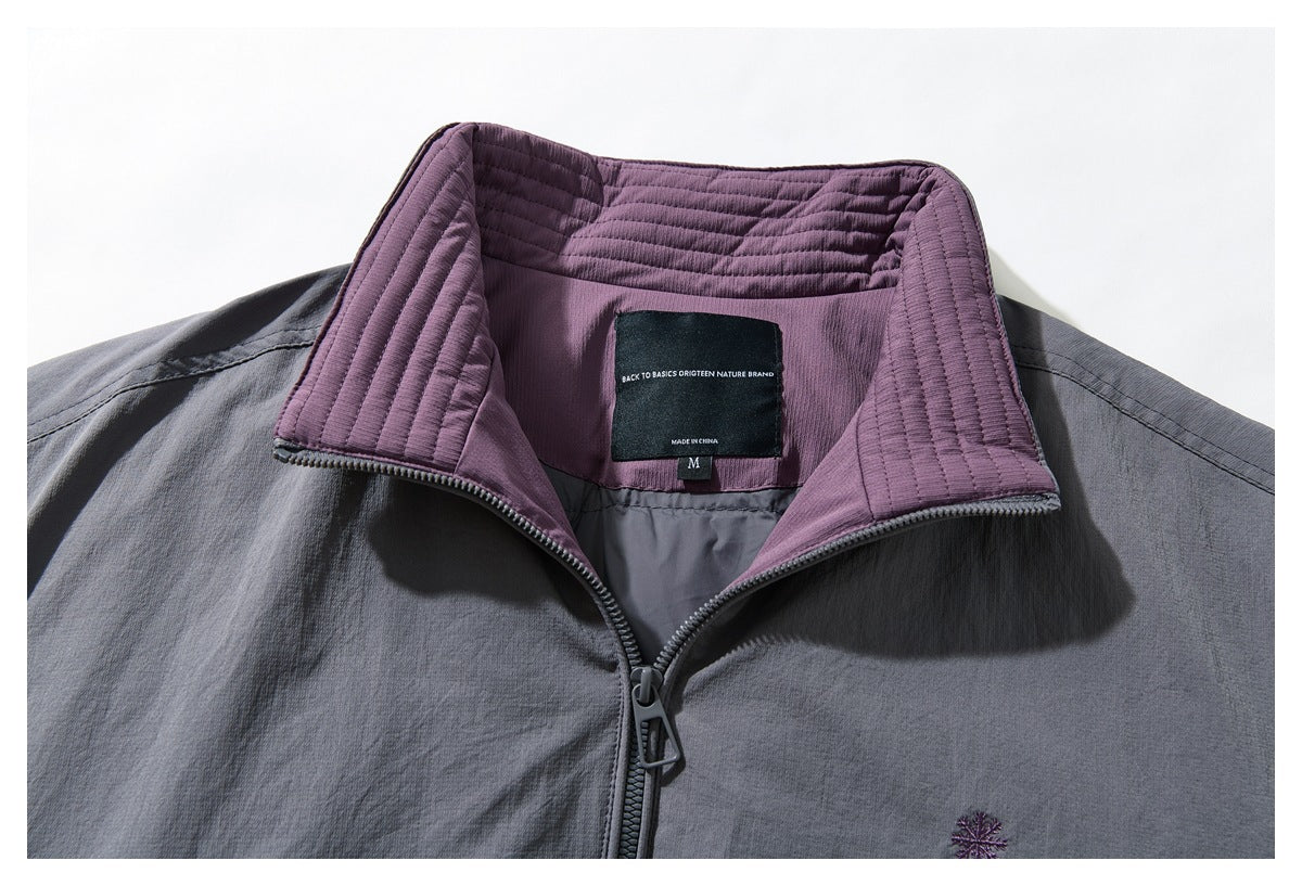 Inside view of the jacket’s purple quilted collar, neck label, size tab, and partially open zipper.