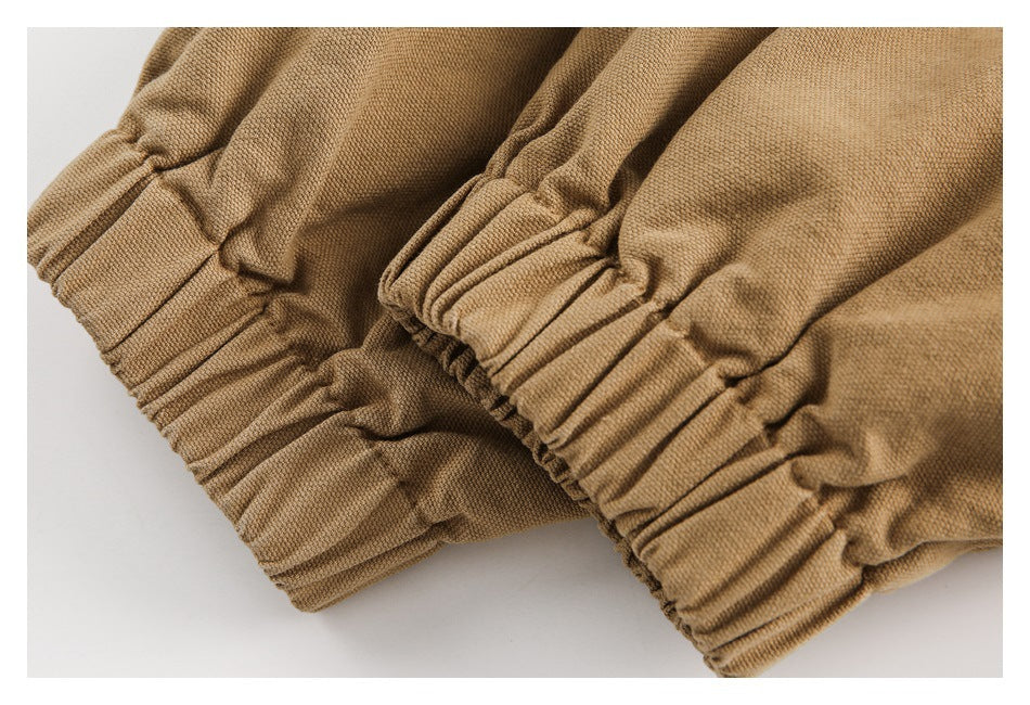 Close-up of gathered elastic cuffs on camel-brown garment fabric.
