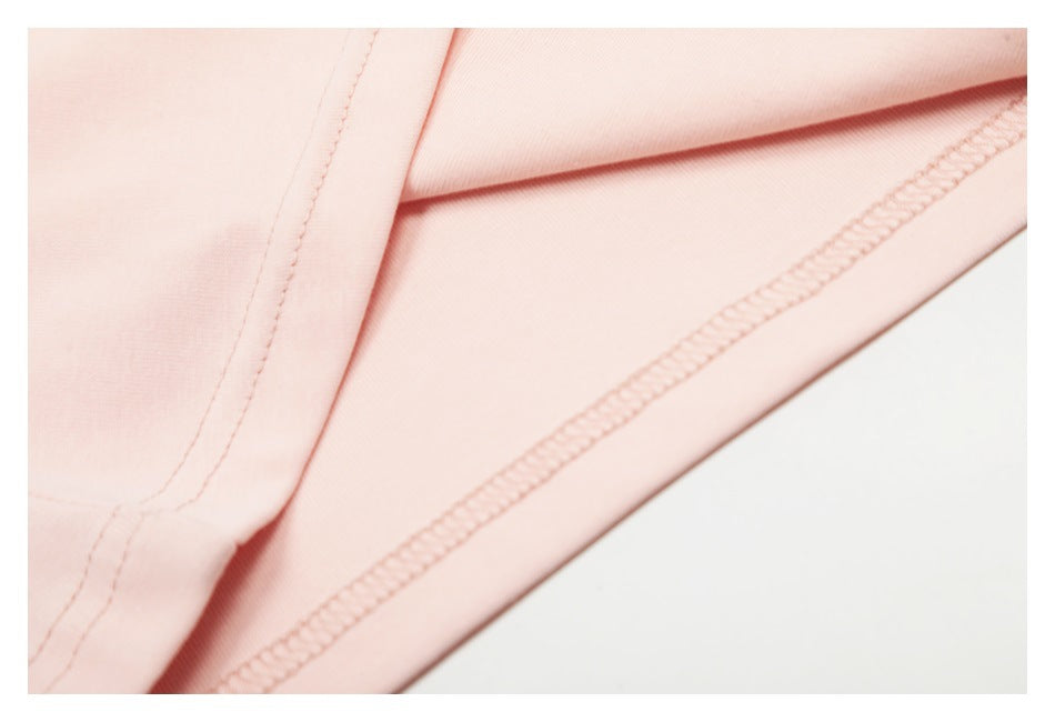 Close-up of pale pink garment fabric showing an interior seam and overlock stitching.