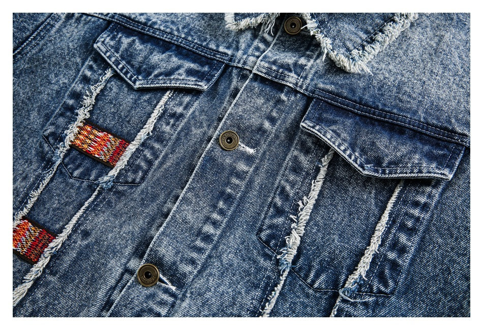 Close-up of the jacket front showing button closure, flap pockets, frayed seams and colorful woven tabs.