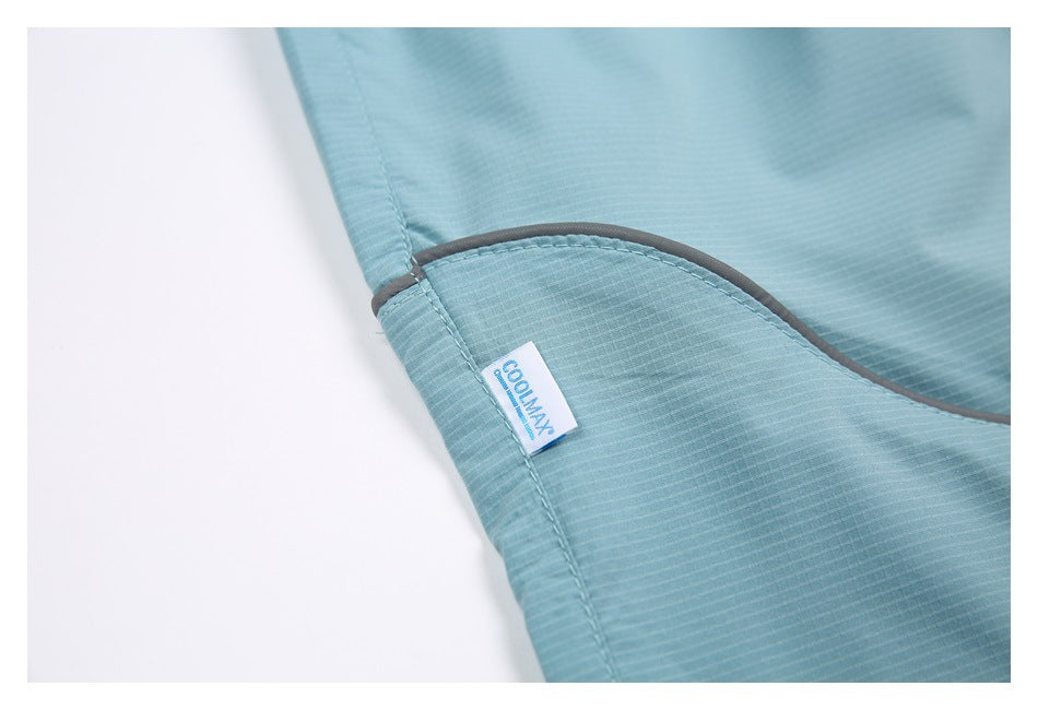 Close-up of an aqua shorts seam with gray piping and a small COOLMAX label.