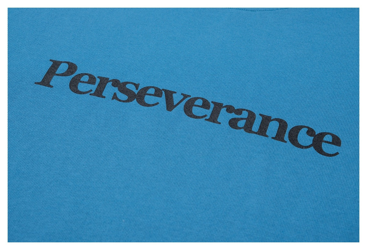 Close-up of black “Perseverance” lettering printed on blue T-shirt fabric.