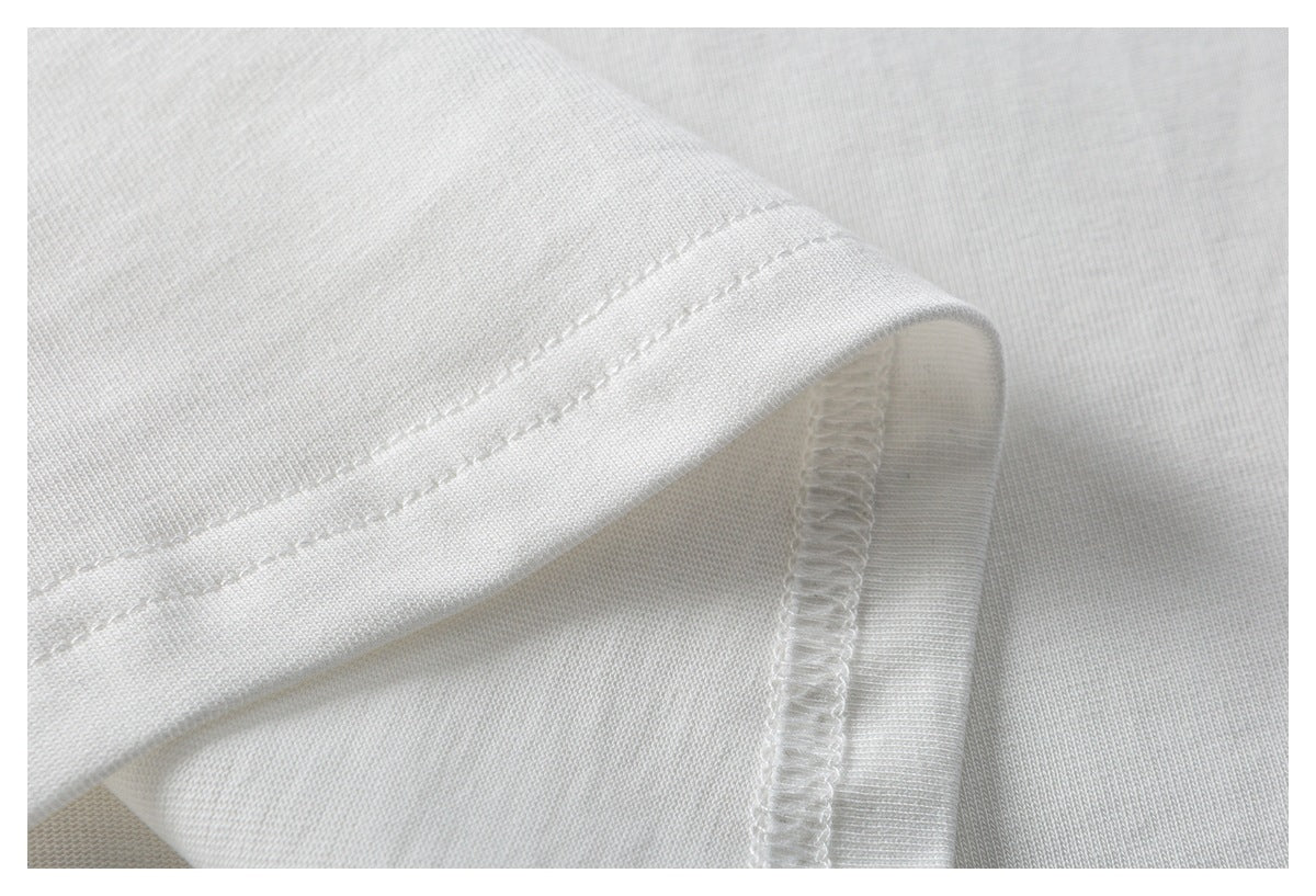 Close-up of a white T-shirt hem with parallel stitching and an overlocked inside seam.