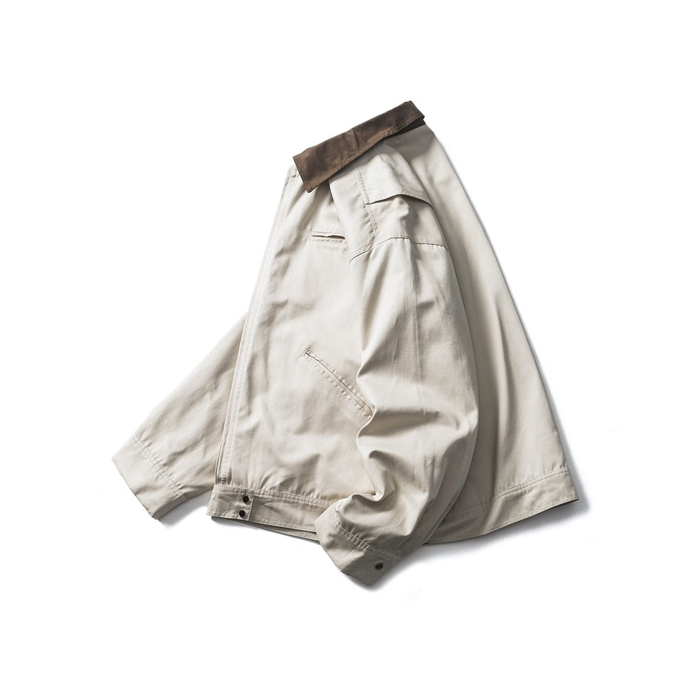 Angled view of an ivory jacket showing its brown collar, chest pocket, and front pockets.