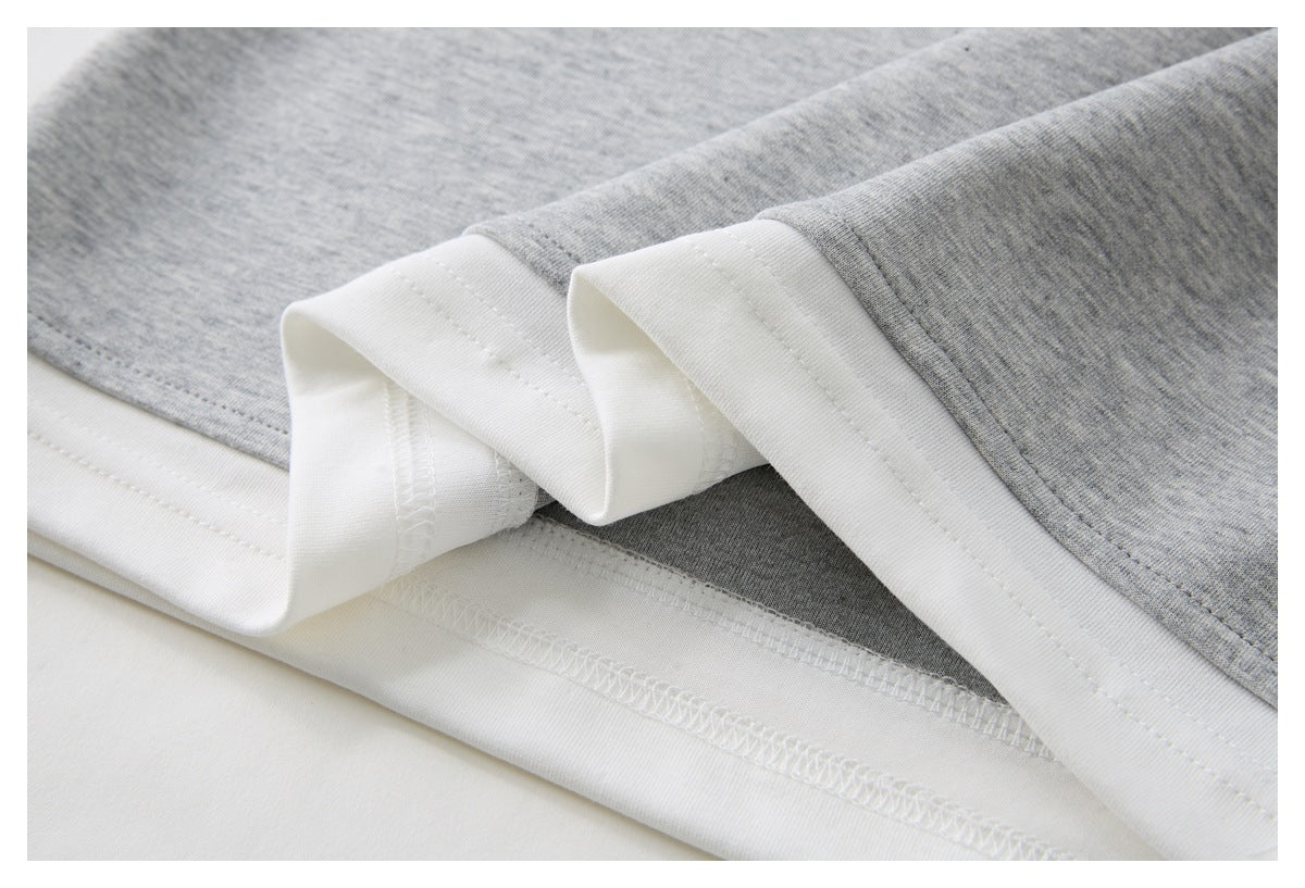 Close-up of a heather gray garment hem, showing white inner fabric and stitching.