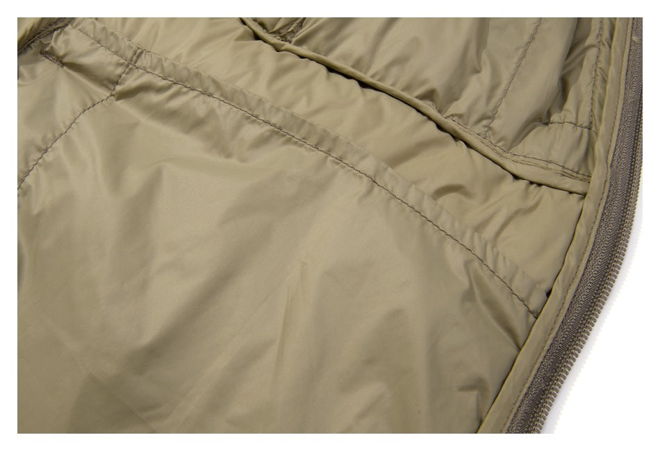 Close-up of the tan jacket's interior lining, curved stitched seams, and zipper edge.
