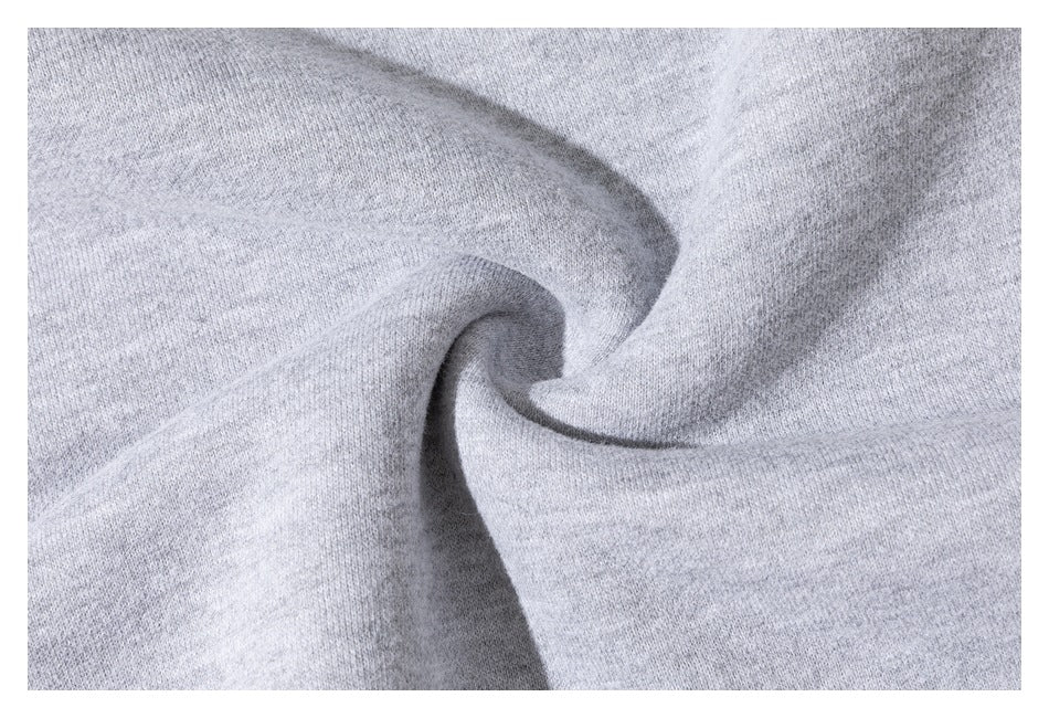 Close-up of the heathered light gray sweatshirt fabric arranged in soft folds.
