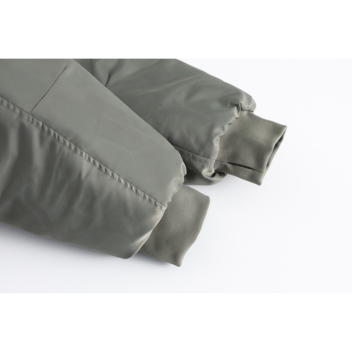 Close-up of the olive-gray jacket's sleeve seams and ribbed cuffs.